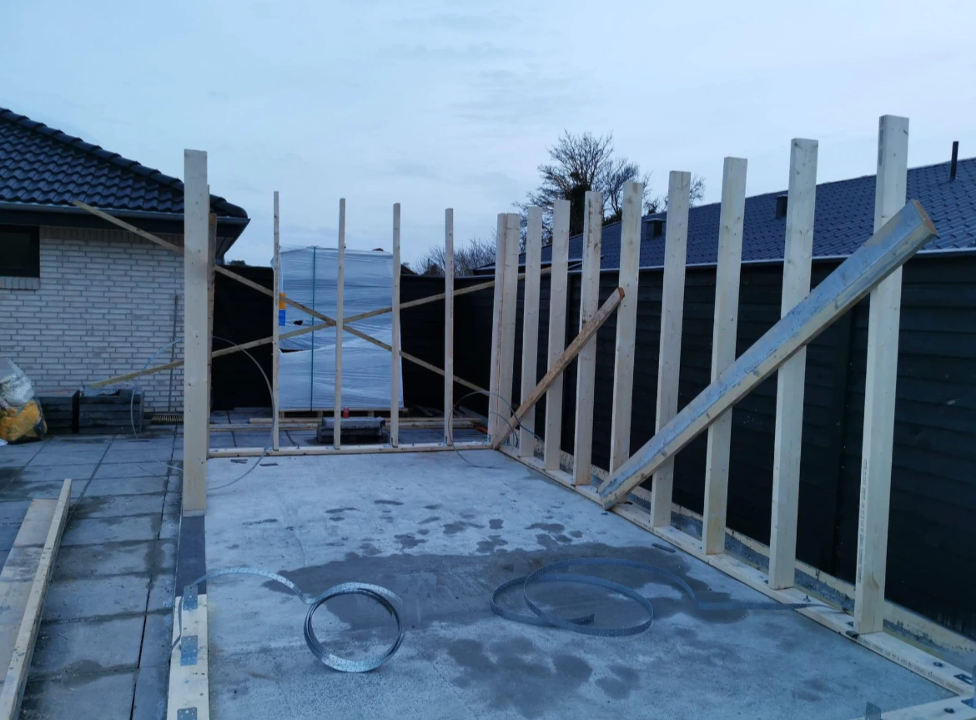 Nybyggeri af garagevæg med trærammer og konstruktion.