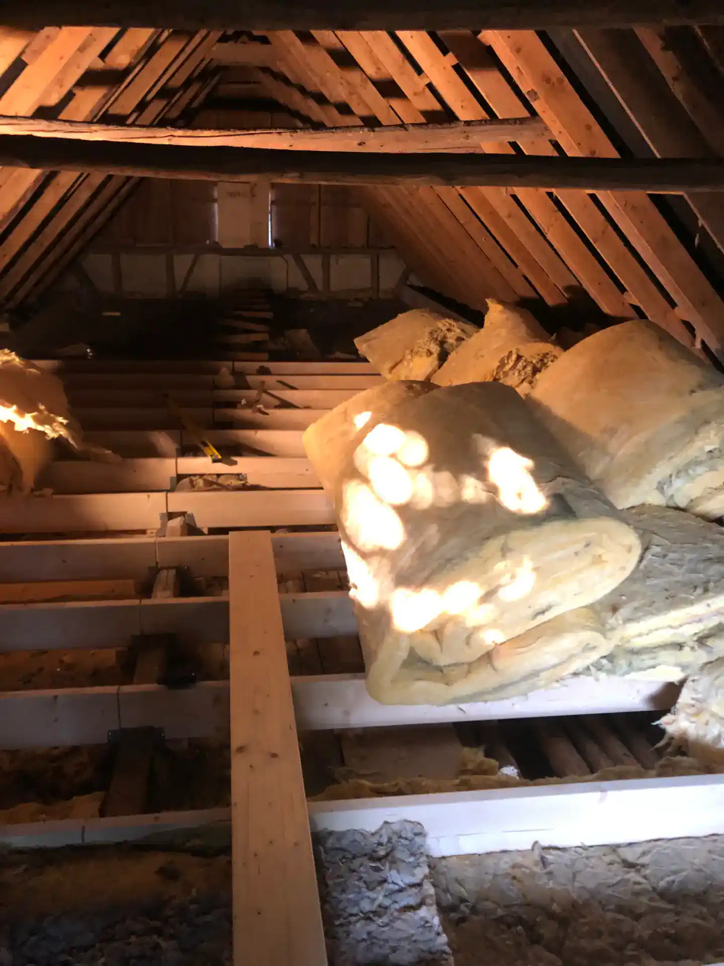 Isolering i tagkonstruktion med træbjælker og isoleringsmateriale.