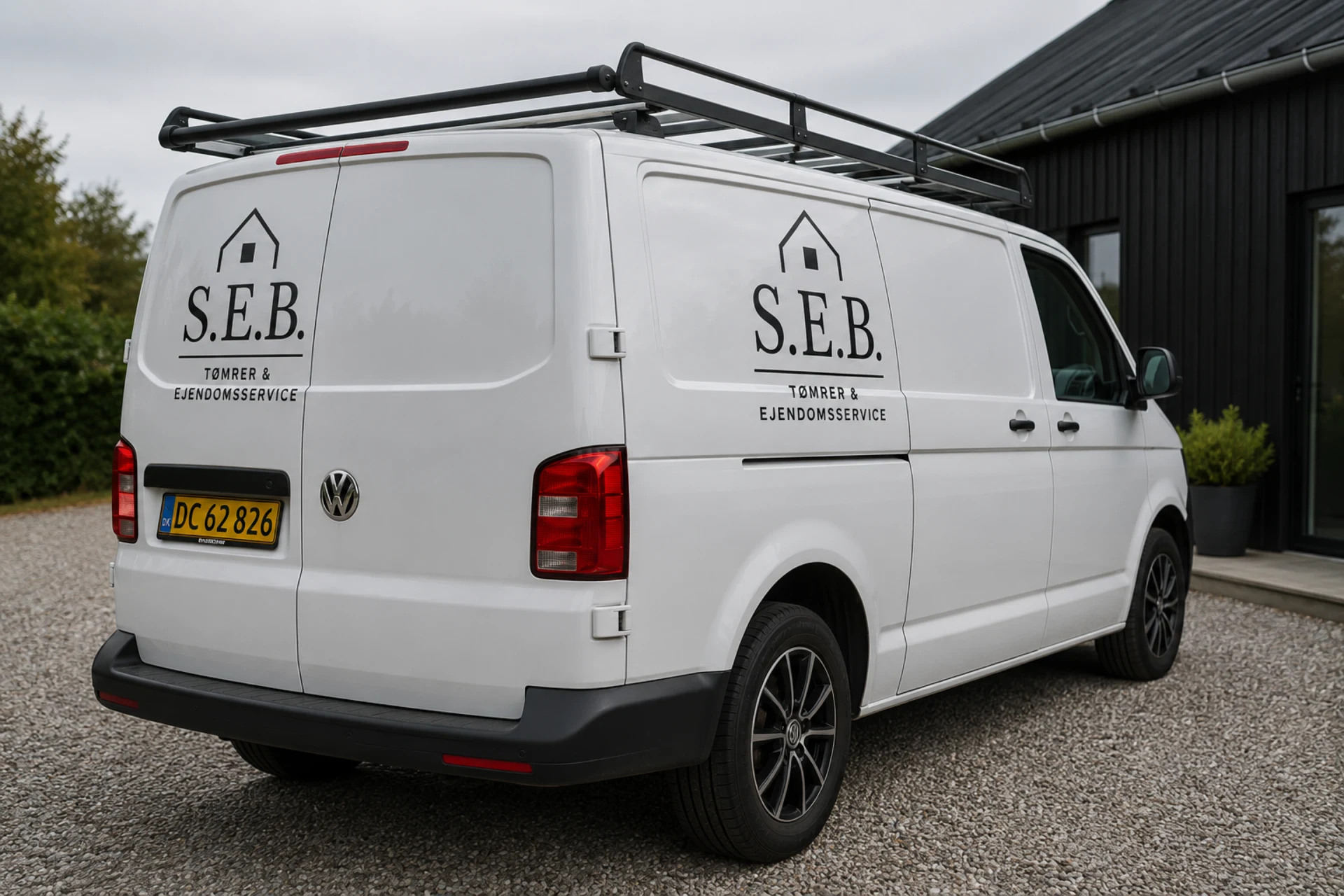 S.E.B Tømrer & Ejendomsservice firmabil med logo i grå farve.