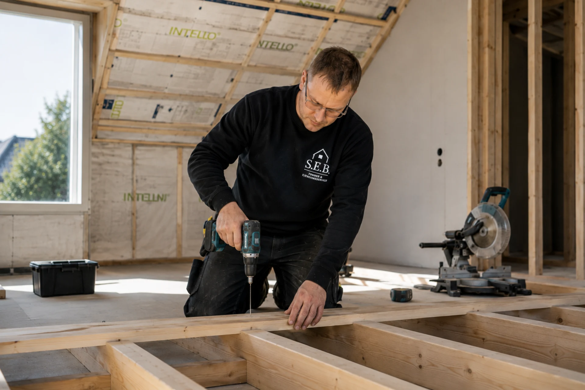Tømrer arbejder med træ i et nyt byggeri under tagkonstruktion.
