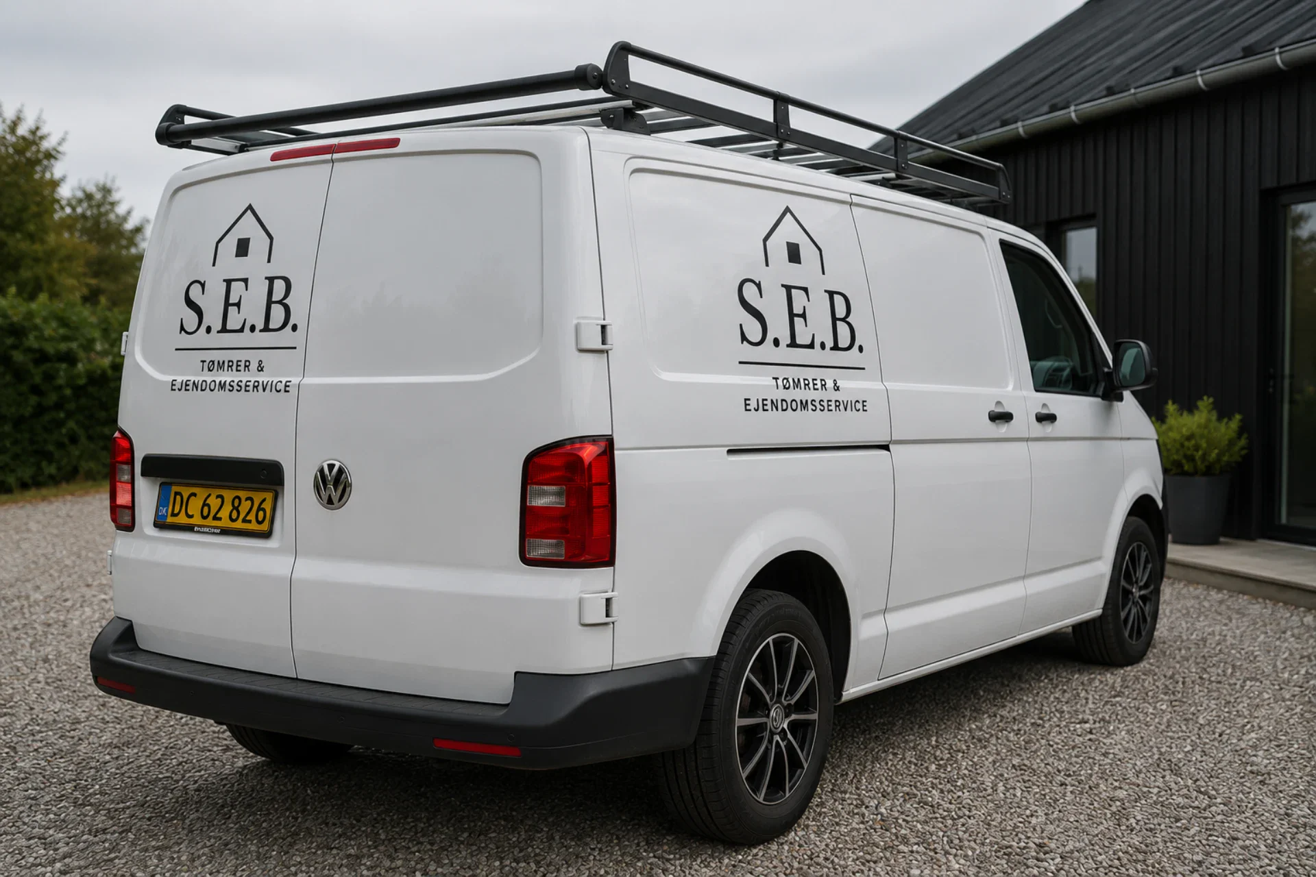 S.E.B Tømrer & Ejendomsservice firmabil med logo og tagbøjler.
